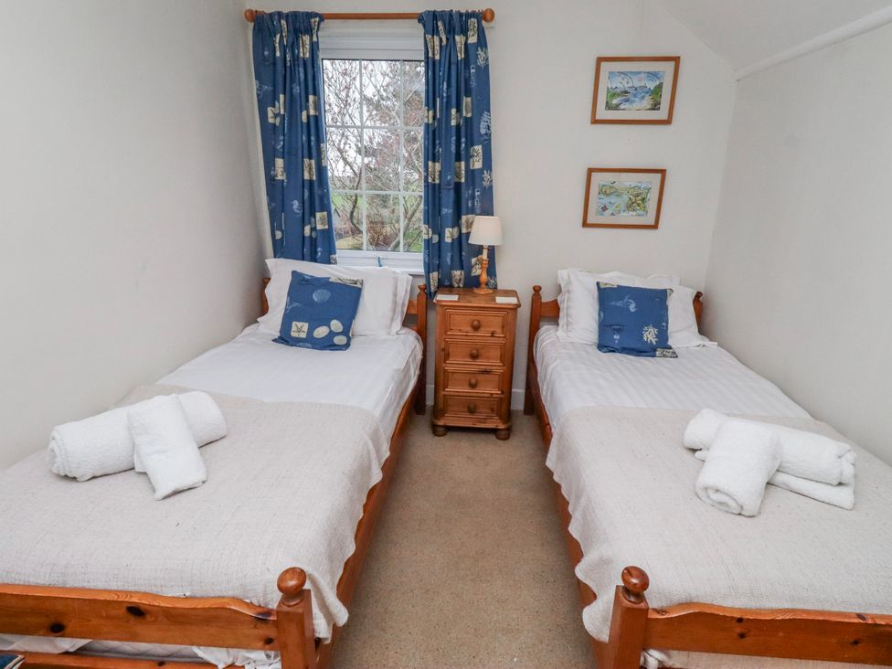 A bedroom with two beds and a bedside table at St Marys Cottages No4 in Low Newton-by-the-Sea