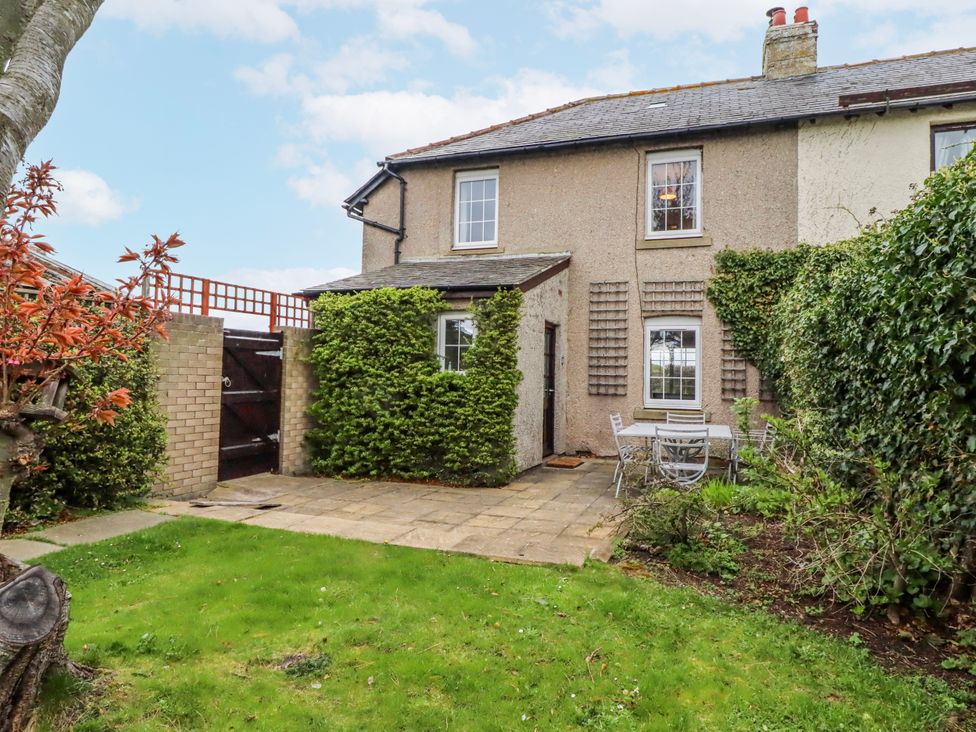 A garden with a patio table and chairs at St Marys Cottages No4 in Low Newton-by-the-Sea