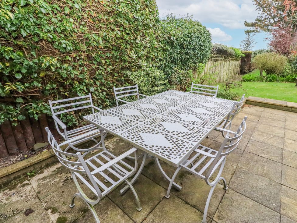 An outdoor seating area with a metal table and chairs at St Marys Cottages No4 Low Newton-by-the-Sea