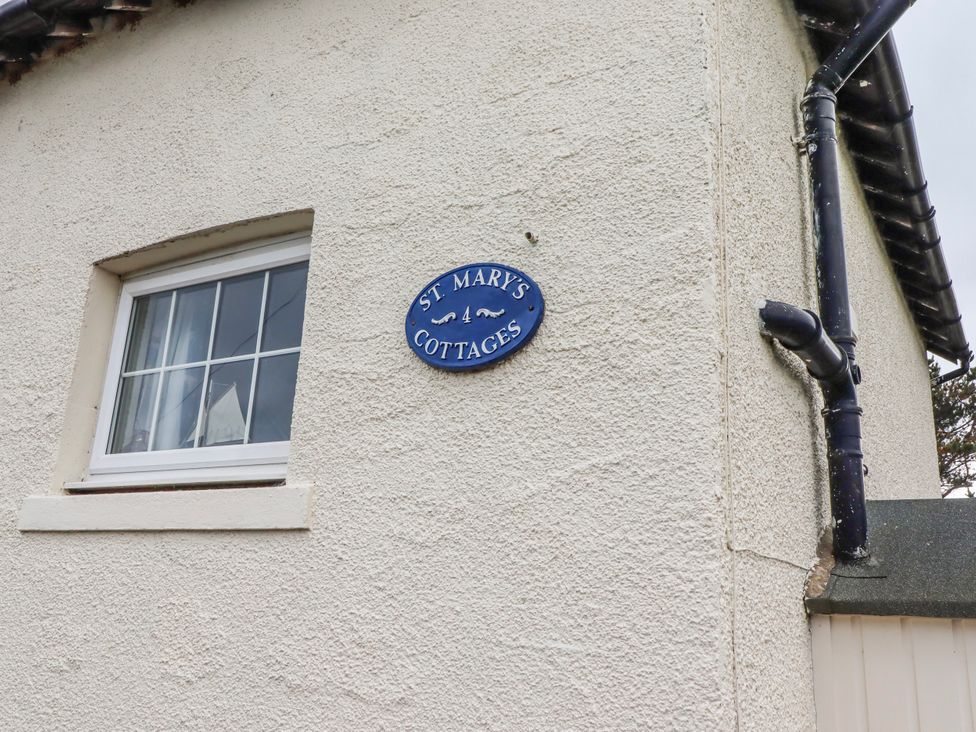 A sign indicating St Mary's Cottages No4 in Low Newton-by-the-Sea