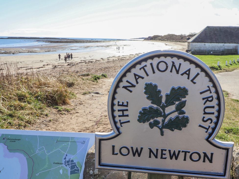 A beach with a National Trust sign at Low Newton-by-the-Sea