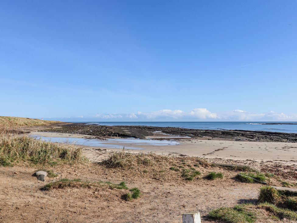 A beach area with rocks and ocean at St Marys Cottages No4 Low Newton-by-the-Sea