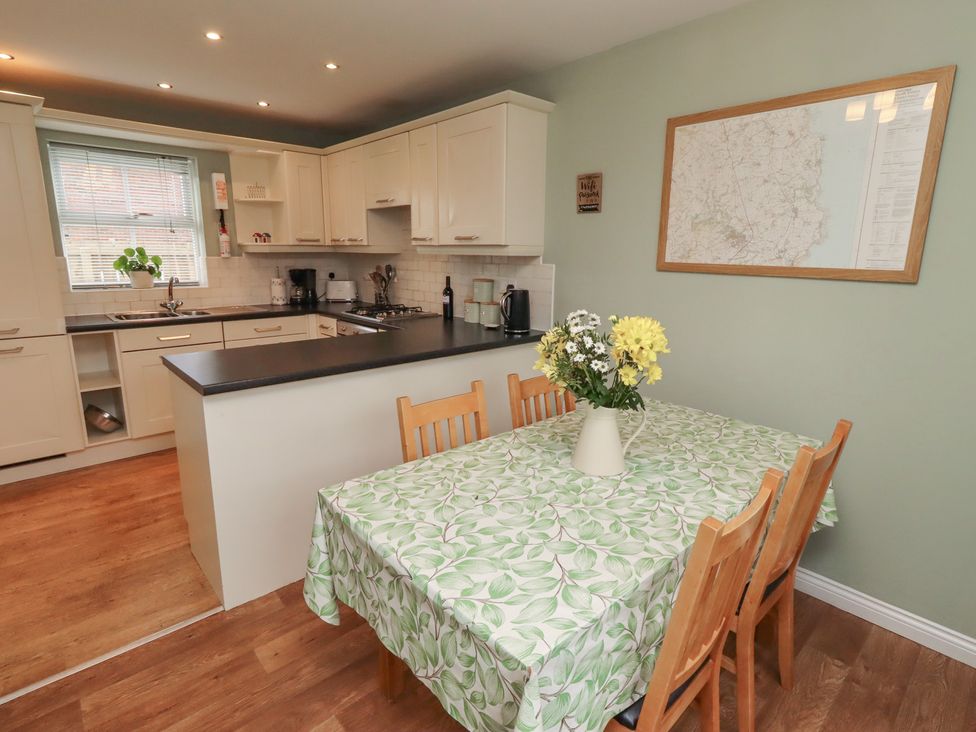 A kitchen with a table and chairs at Sugar Sands in Longhoughton
