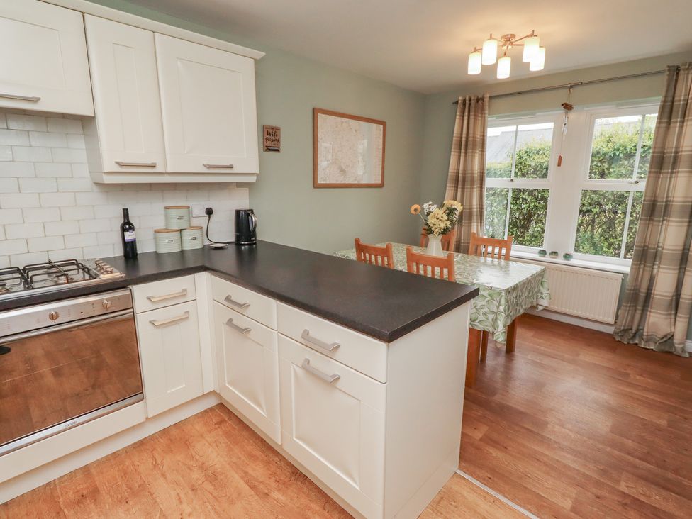 A kitchen with a stove, sink, and dining area at Sugar Sands in Longhoughton