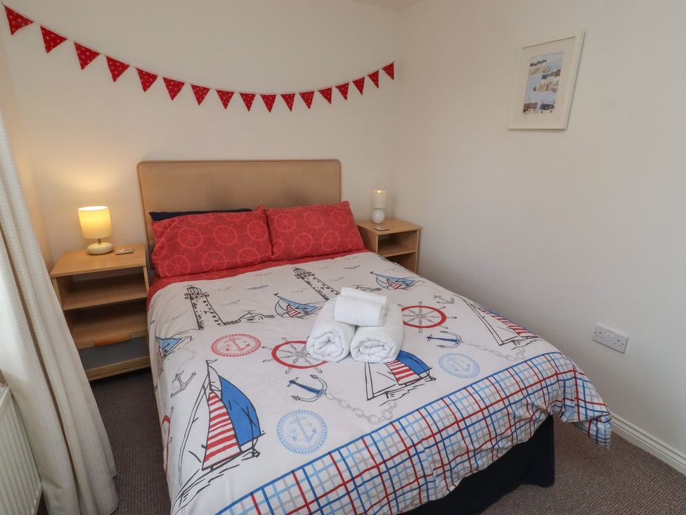 A bedroom featuring a bed with a nautical themed blanket at Sugar Sands in Longhoughton
