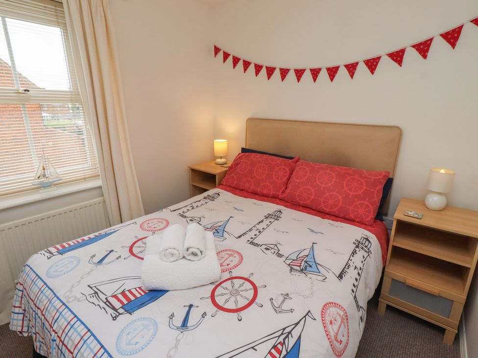 A bedroom with a bed and lamp at Sugar Sands in Longhoughton