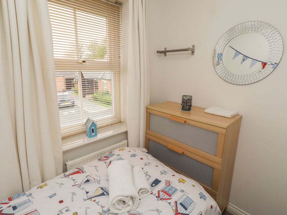 A bedroom with a bed and chest of drawers at Sugar Sands in Longhoughton