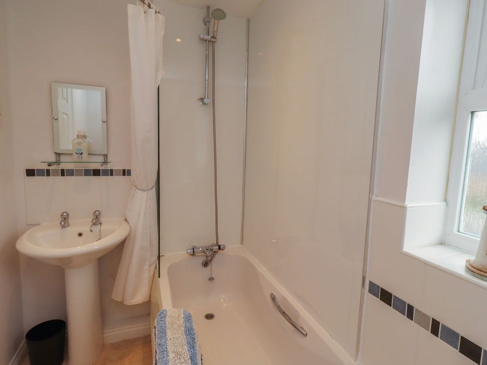 A bathroom with a bathtub and sink at Sugar Sands in Longhoughton