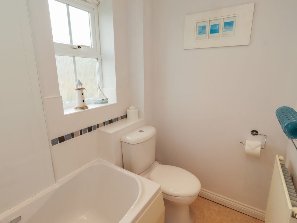 A bathroom with a bath tub and toilet at Sugar Sands in Longhoughton