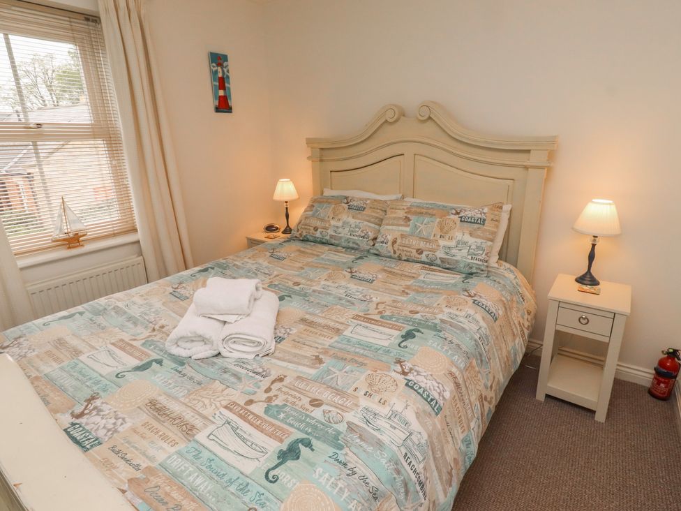 A bedroom with a double bed and bedside tables at Sugar Sands in Longhoughton