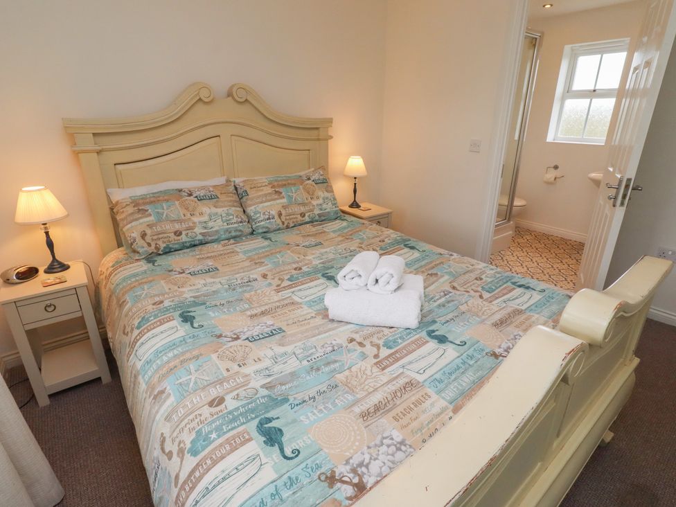 A bedroom with a bed and bathroom view at Sugar Sands Longhoughton
