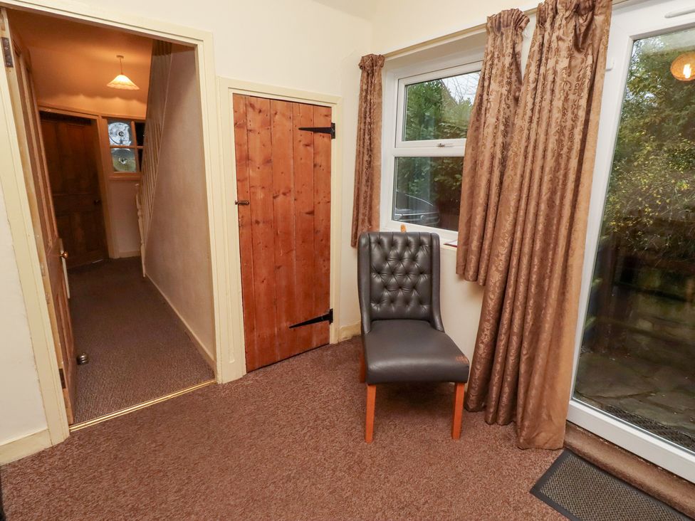 An entrance hall with a chair and window at Wayside Cottage in Newton-by-the-Sea