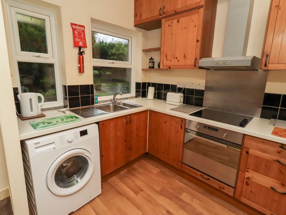 A kitchen with a sink and appliances at Wayside Cottage in Newton-by-the-Sea