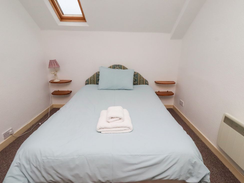 A bedroom with a bed and lamp at Wayside Cottage in Newton-by-the-Sea