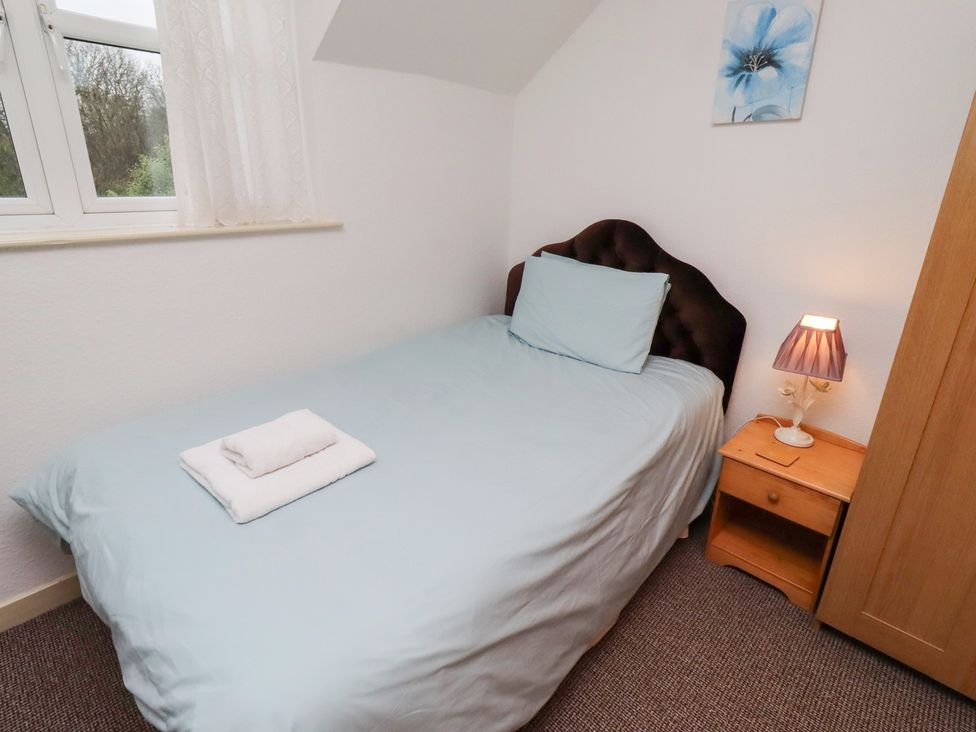 A bedroom with a single bed and bedside table at Wayside Cottage in Newton-by-the-Sea
