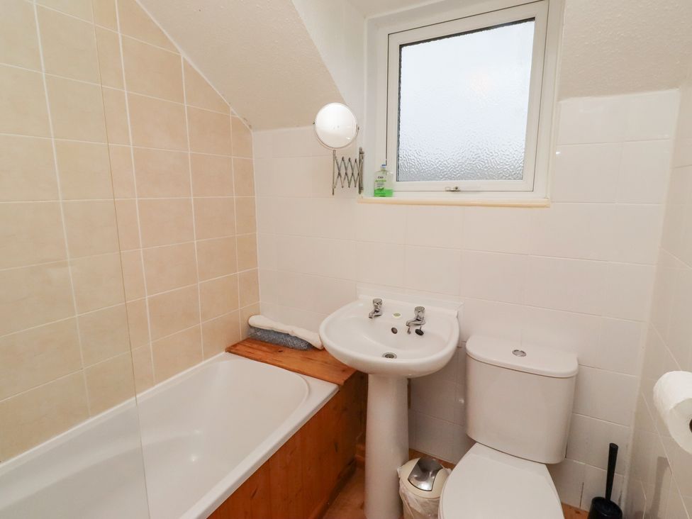 A bathroom with a bathtub, sink, and toilet at Wayside Cottage in Newton-by-the-Sea