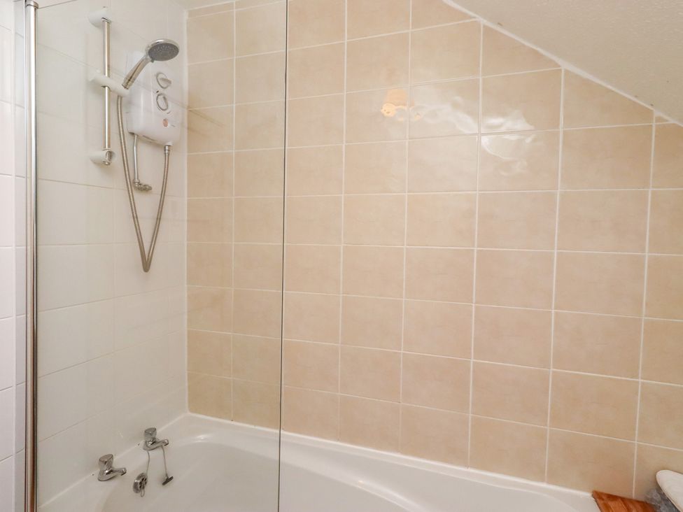 A bathroom with a bathtub and showerhead at Wayside Cottage in Newton-by-the-Sea