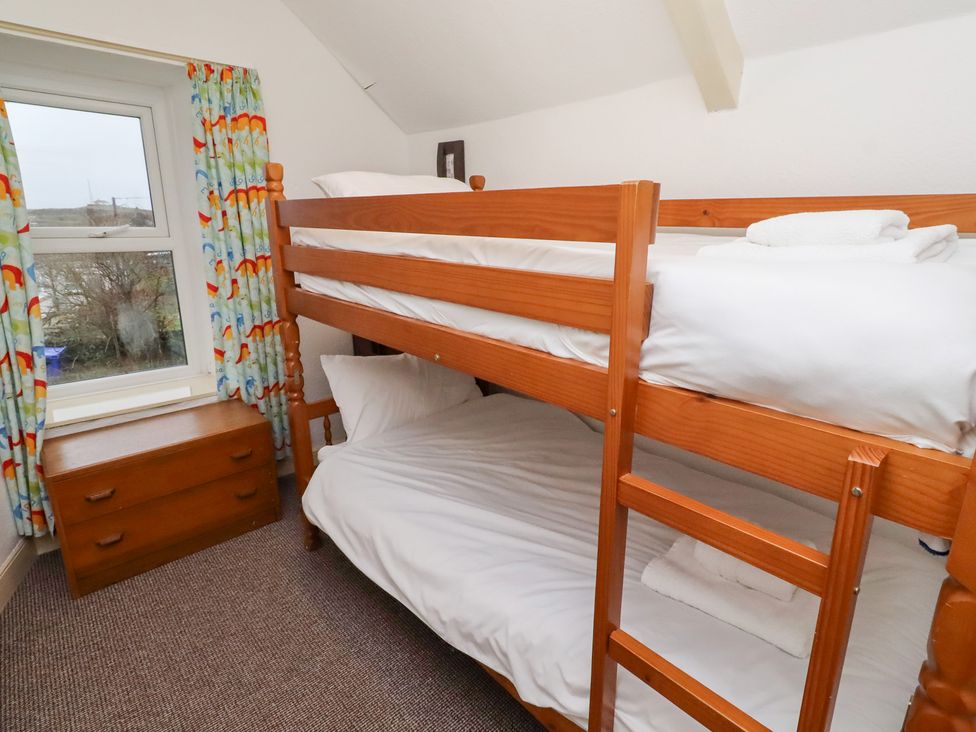 A bedroom with a bunk bed and dresser at Wayside Cottage in Newton-by-the-Sea