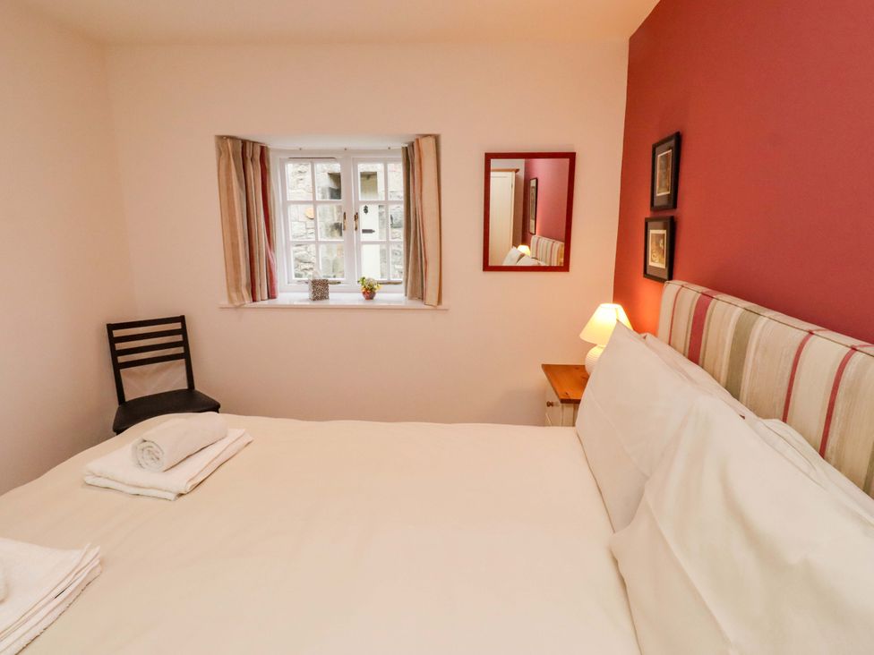 A bedroom with a bed and a chair at Wynding Down in Bamburgh