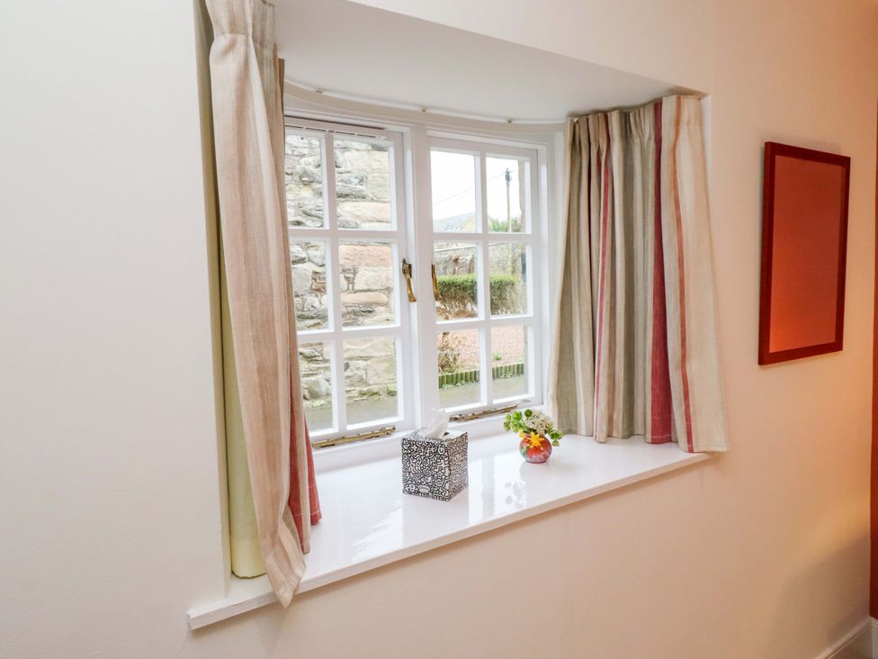 A window with curtains and a vase on the sill at Wynding Down Bamburgh