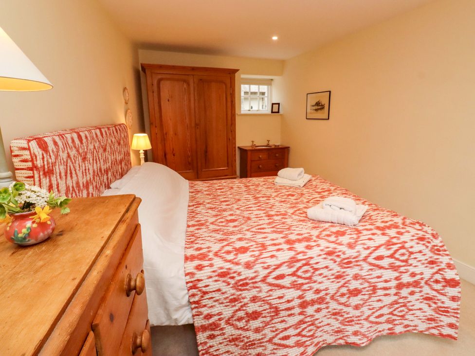 A bedroom with a double bed and wardrobe at Wynding Down in Bamburgh