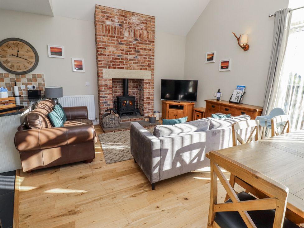 A living room with a fireplace and television at Red Fox in Lucker