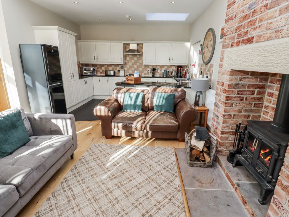 A living room with a sofa and fireplace at Red Fox in Lucker