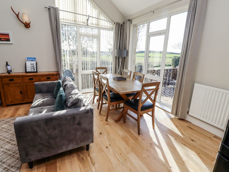 A dining room with a sofa and dining table at Red Fox in Lucker