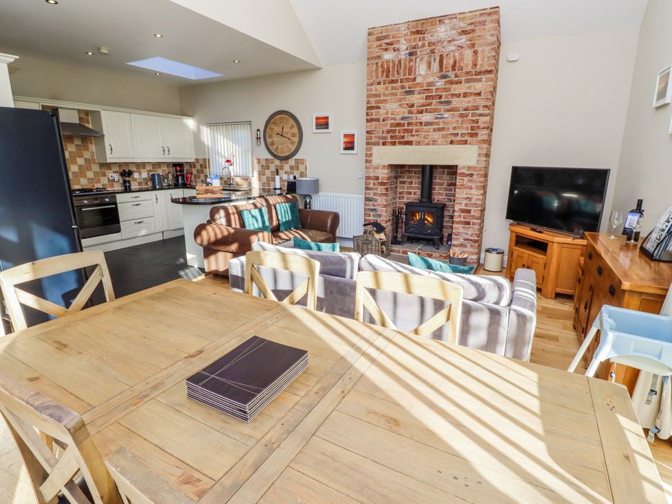 A living room with a fireplace and kitchen in Red Fox, Lucker
