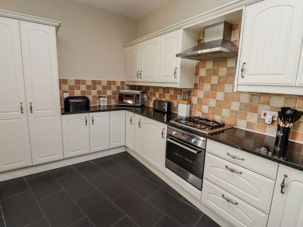 A kitchen with cabinets, oven, and a microwave at Red Fox in Lucker