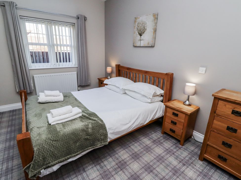 A bedroom with a wooden bed and nightstands at Red Fox in Lucker