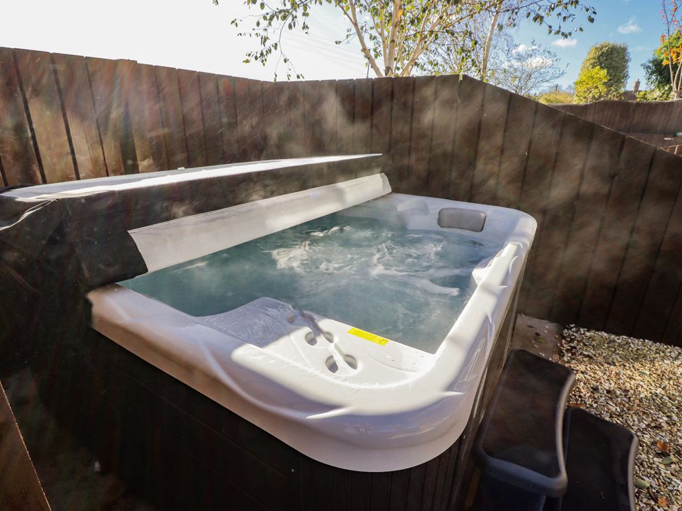 A hot tub surrounded by wooden fencing at Red Fox in Lucker
