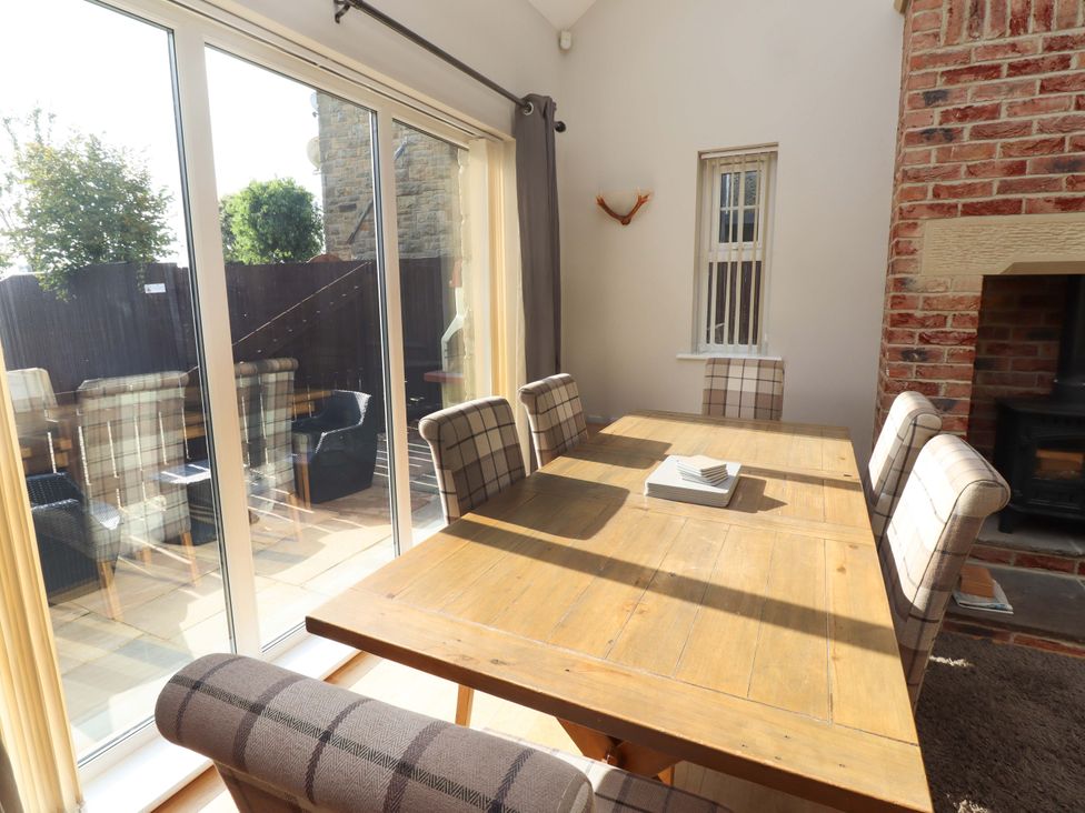 A dining room with a wooden table and chairs at Roe Deer in Lucker