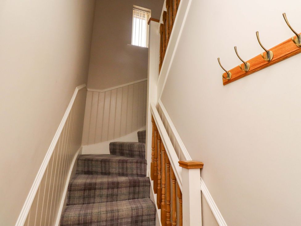 A staircase with a banister and hooks at Roe Deer in Lucker