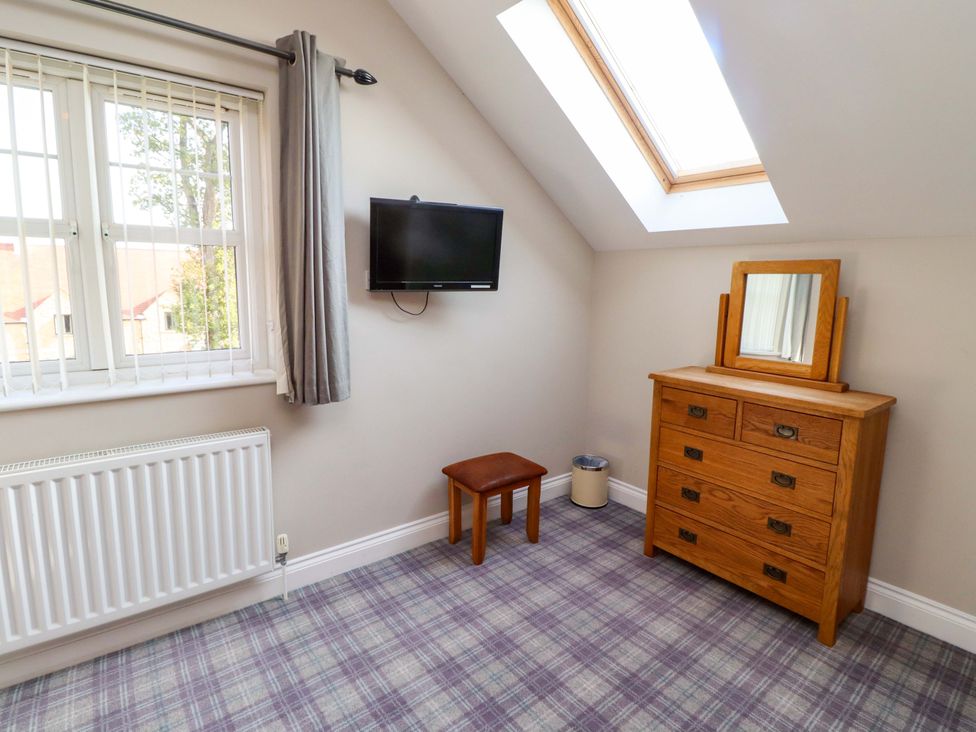 A bedroom with a television and dresser at Roe Deer in Lucker