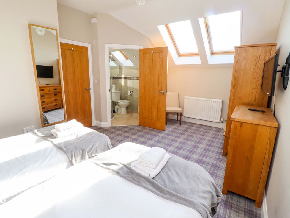 A bedroom with two beds and a television at Roe Deer in Lucker