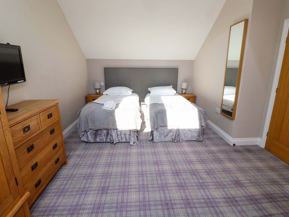 A bedroom with two beds and a television at Roe Deer in Lucker