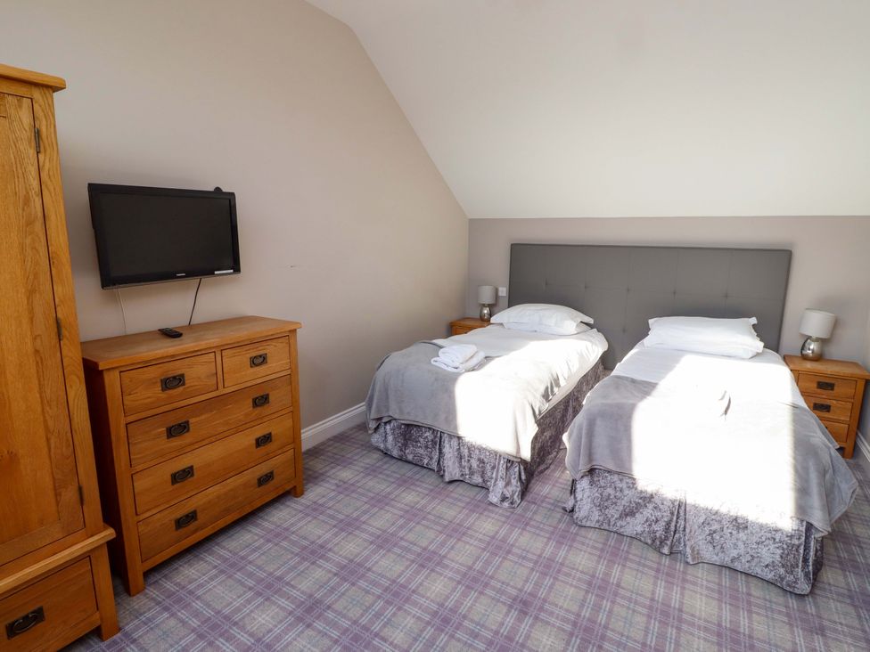 A bedroom with two beds and a television at Roe Deer in Lucker
