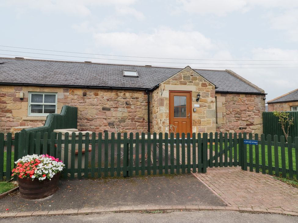 An outdoor area with a stone wall and door at Chiff Chaff in Lucker