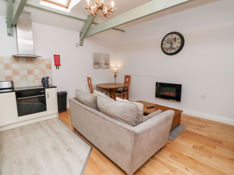 A living room with a sofa and dining table at Chiff Chaff in Lucker