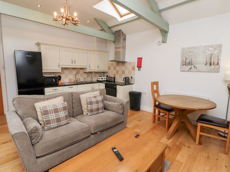 A living room with a sofa and dining area at Chiff Chaff in Lucker