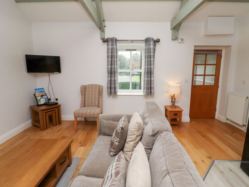 A living room with a sofa and a television at Chiff Chaff in Lucker