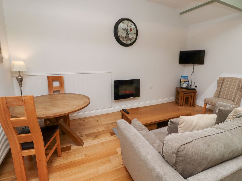 A living room with a table and sofa at Chiff Chaff in Lucker