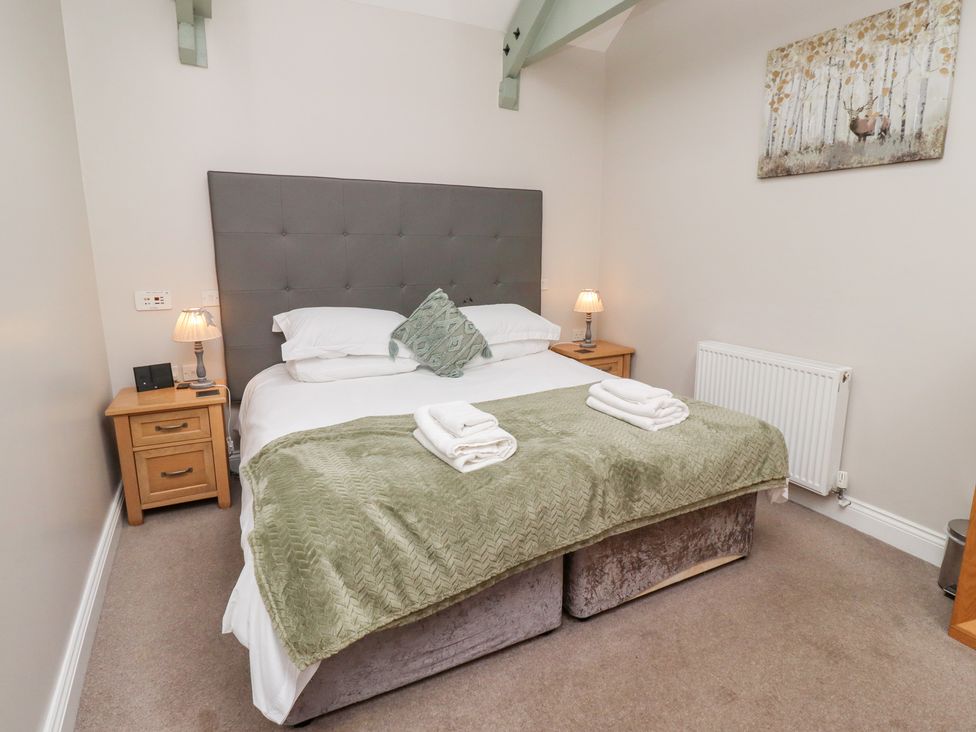 A bedroom with a bed and bedside tables at Chiff Chaff in Lucker