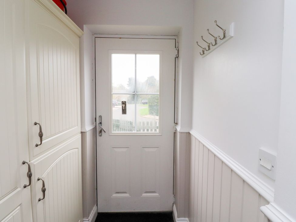 A hallway with a door and storage cabinets at Chiff Chaff in Lucker