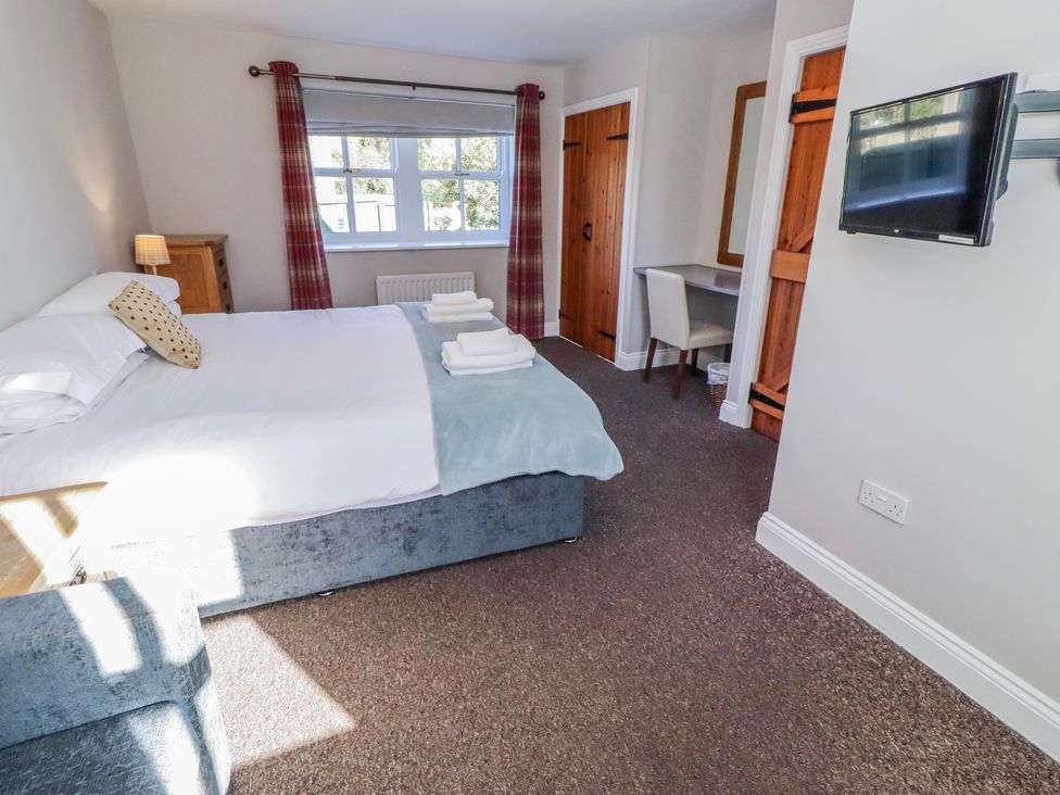 A bedroom with a bed and a desk at Greenfinch in Lucker
