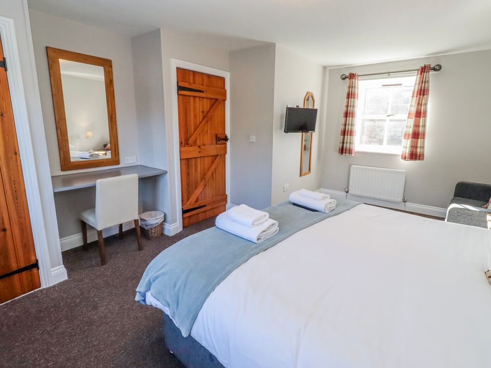 A bedroom with a bed and desk at Greenfinch in Lucker