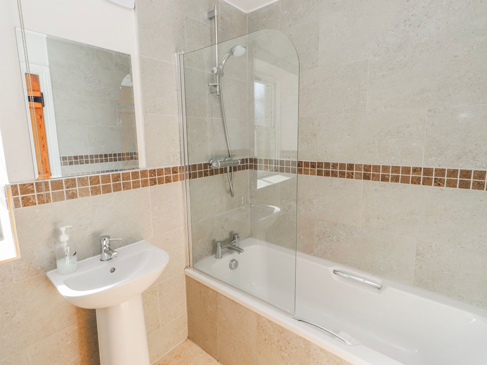 A bathroom with a bathtub and sink at Greenfinch in Lucker