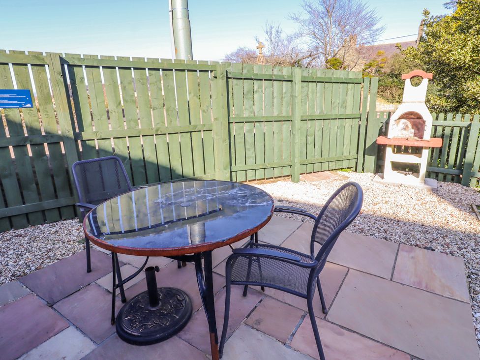 An outdoor patio with a table and chairs at Greenfinch in Lucker