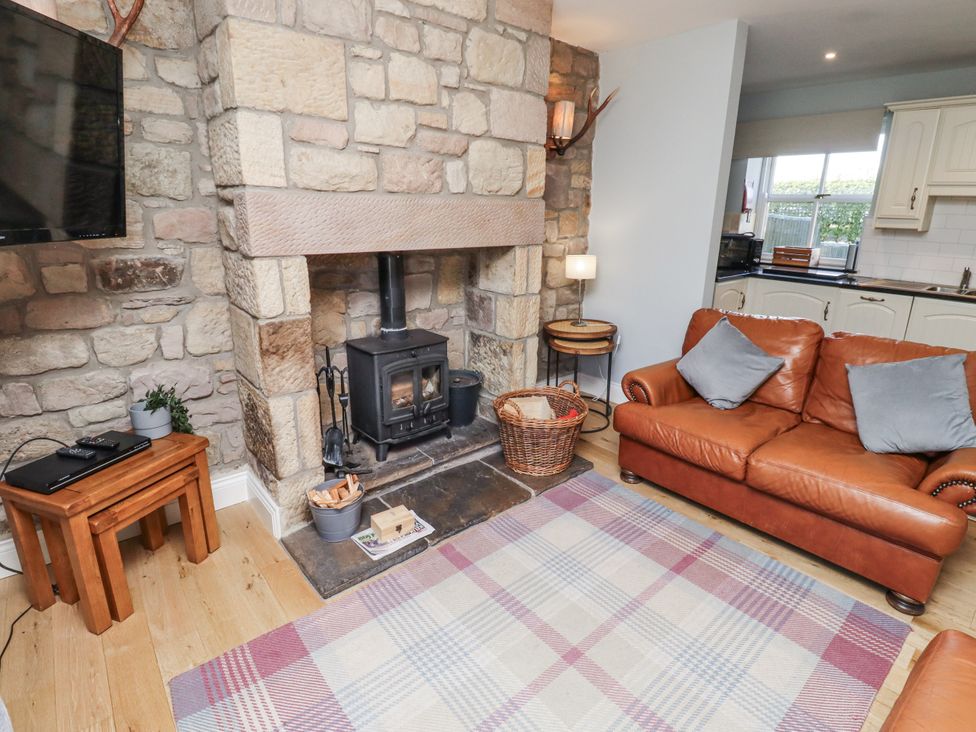 A living room with a fireplace and sofa at Rosefinch in Lucker